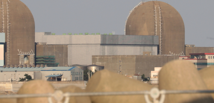 Domed structures and surrounding buildings at Kori nuclear power plant beyond a breakwater