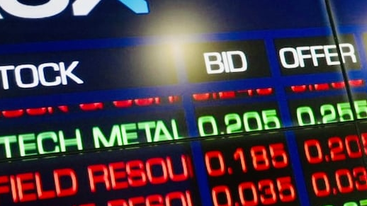 Close-up of an ASX electronic stock quotation board showing red and green prices and reflections on the screen.