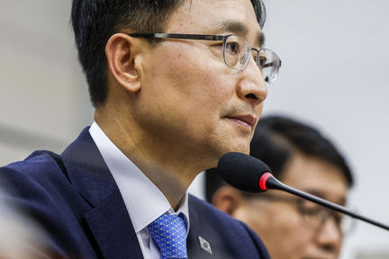 Presidential Chief of Staff Lim Kwang-hyun, wearing glasses and a suit, seated at a microphone in a National Assembly meeting room