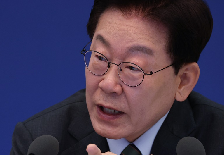 이재명 대통령이 마이크 앞에서 손짓하며 발언하는 모습