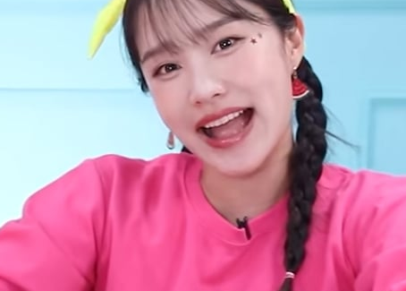 Hey Jini wearing a pink top and a yellow headband
