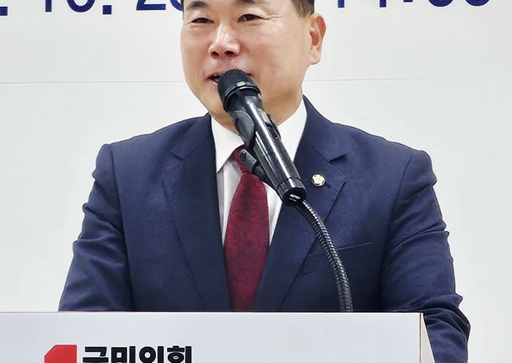 A man in a suit standing at a microphone behind a lectern bearing the People Power Party name