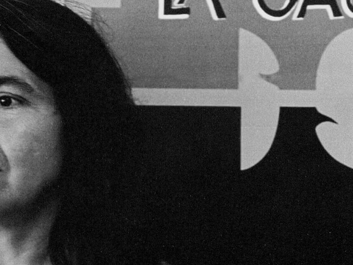 Partial view of Dolores Huerta at the left edge of a black-and-white photograph, beside part of a labor-movement sign.