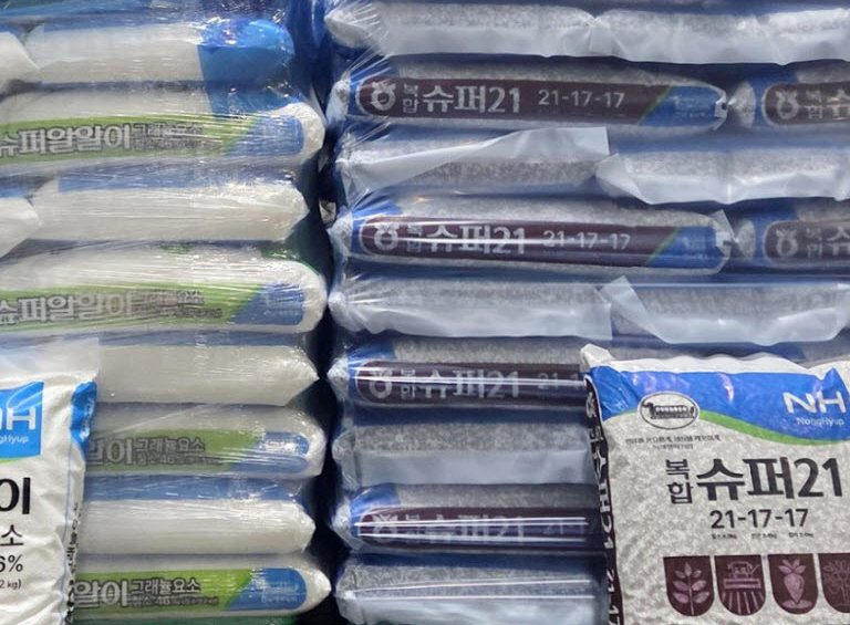 창고에 쌓인 비료 포대와 앞쪽의 농협 비료 제품