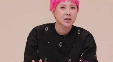 Seo In-young, with pink hair, sits at a table and speaks