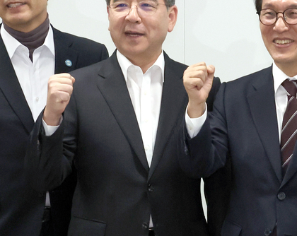 Kim Min-seok and other participants standing together with raised fists for a commemorative photograph at the Saemangeum on-site meeting