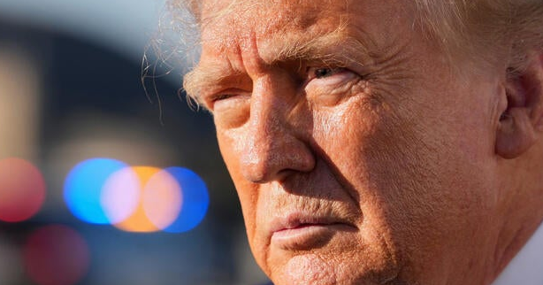 Close-up of Donald Trump outdoors, with blurred lights in the background.
