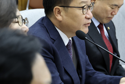 People Power Party floor leader Jung Jeom-sik speaking into a microphone at a meeting