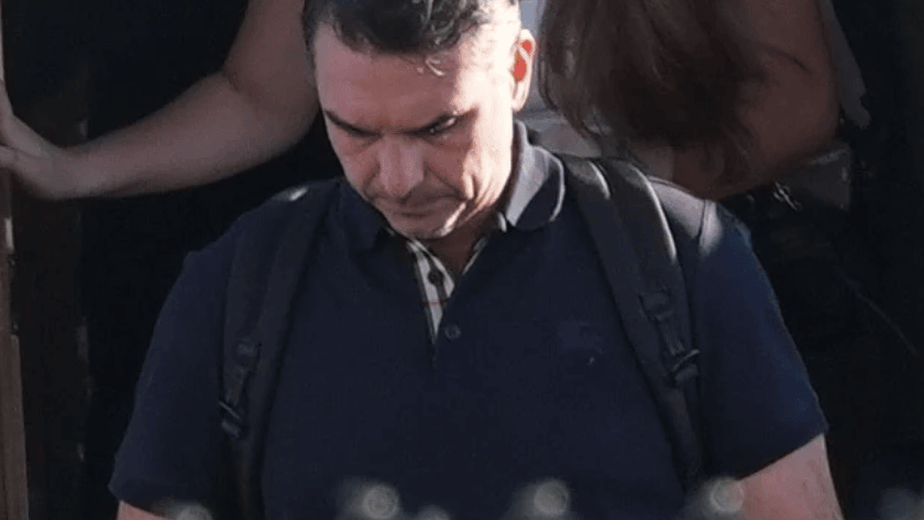 Flávio Bolsonaro wearing a backpack at an aircraft doorway, with another person behind him.